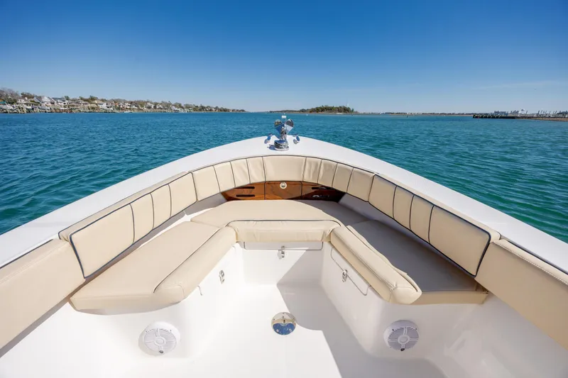 Slide: The Image of 2022 Vanquish Bristol Harbor 23 CC boat with beige seating on calm water. - 18