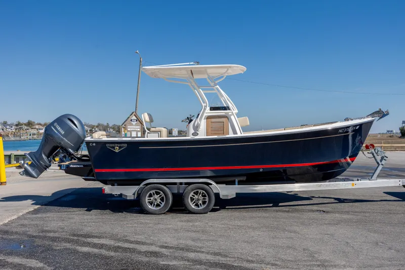 Slide: The Image of 2022 Vanquish Bristol Harbor 23 CC boat on trailer, parked near waterfront. - 31