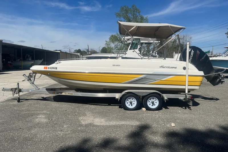 Slide: The Image of 2017 Godfey Hurricane SS 210 boat on trailer, yellow and white design, parked outdoors. - 0