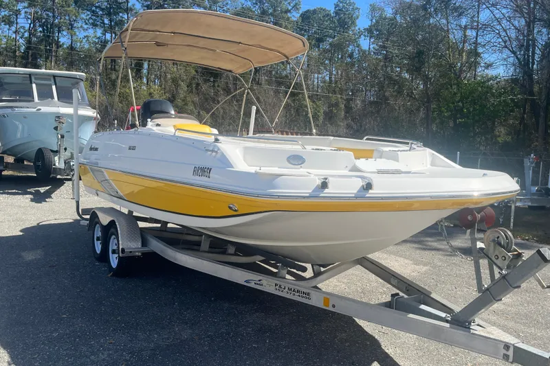 Slide: The Image of 2017 Godfey Hurricane SS 210 boat on trailer, yellow and white, parked outdoors. - 3