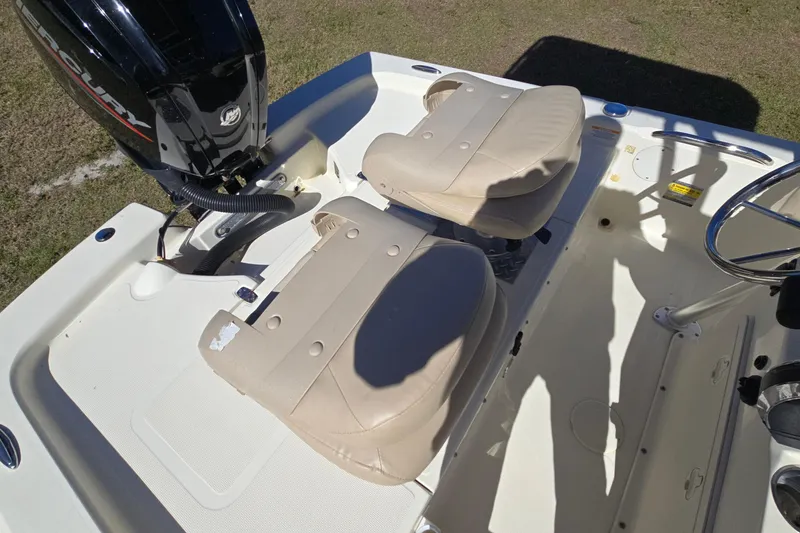 Slide: The Image of 2016 Scout 177 Sport boat interior with beige seats and Mercury engine. - 3