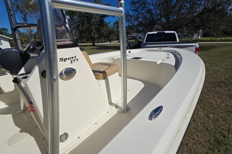 Slide: The Image of 2016 Scout 177 Sport boat with seating, parked near a white truck on grass. - 6