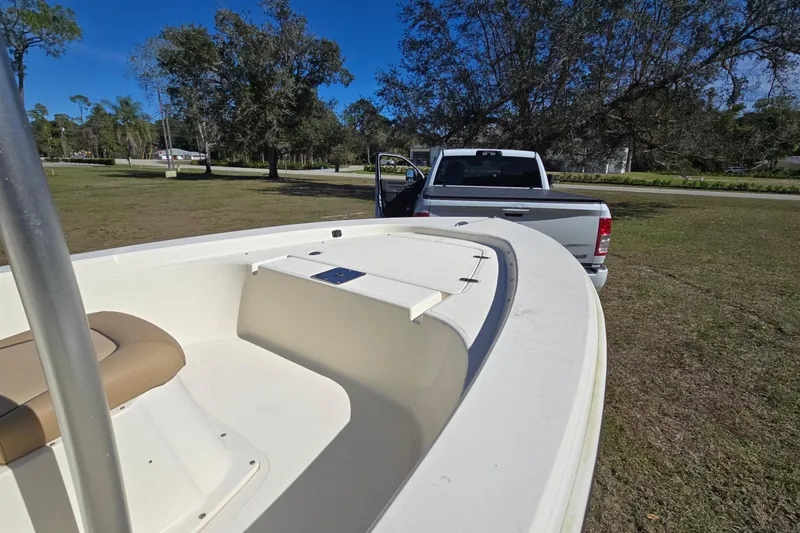 Slide: The Image of 2016 Scout 177 Sport boat on trailer, parked near a white truck in a grassy area. - 7