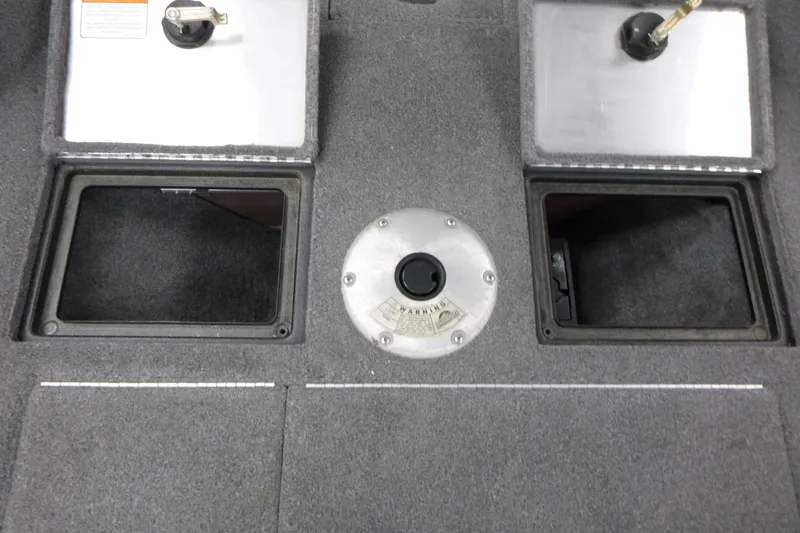 Slide: The Image of 2015 Tracker Pro Guide V-16 SC boat interior with storage compartments and carpeted flooring. - 11