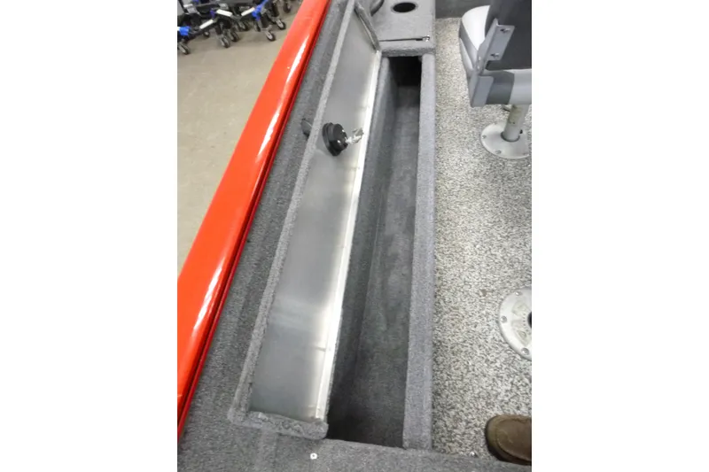 Slide: The Image of 2015 Tracker Pro Guide V-16 SC boat interior storage compartment with gray carpet and seating. - 13