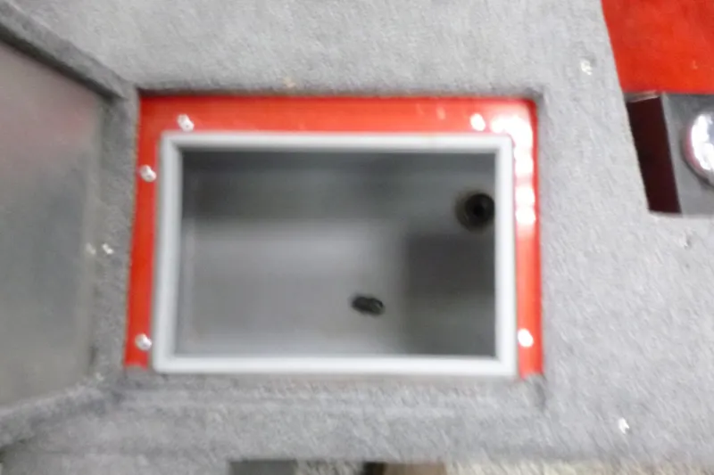 Slide: The Image of Storage compartment in 2015 Tracker Pro Guide V-16 SC boat, featuring red trim and gray interior. - 14