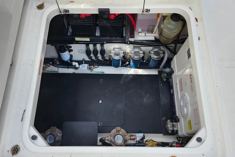Slide: The Image of Engine compartment of 2026 Pursuit S 388 Sport boat, showcasing batteries and mechanical components. - 32