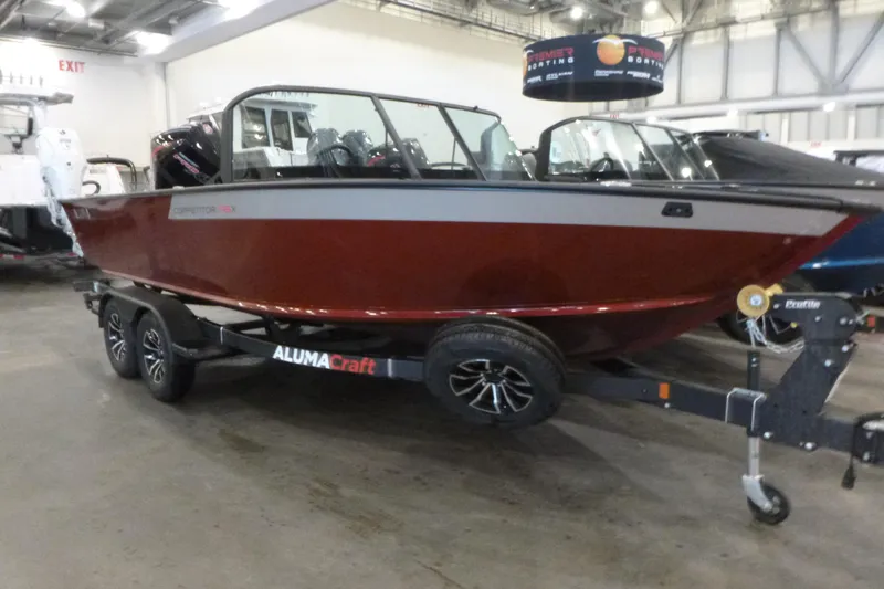 Slide: The Image of 2025 Alumacraft Competitor 195X Sport boat on display in an indoor showroom. - 3
