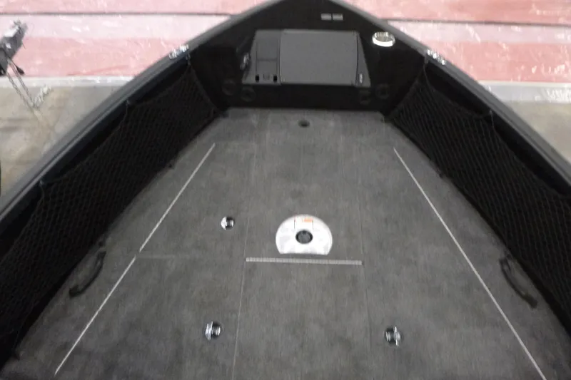 Slide: The Image of 2025 Alumacraft Competitor 195X Sport boat interior with carpeted deck and storage compartments. - 6