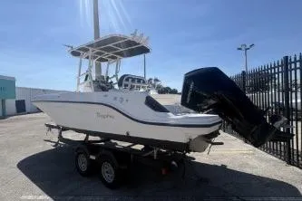 Slide: The Image of 2023 Trophy T22 boat on trailer, parked outdoors, with outboard motor. - 2