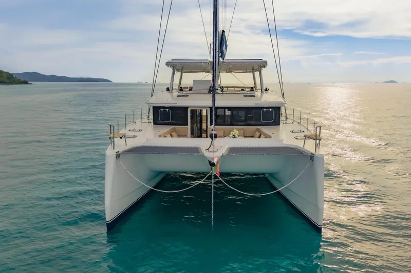 Slide: The Image of 2026 Island Spirit 525E catamaran on tranquil ocean waters under a clear sky. - 12