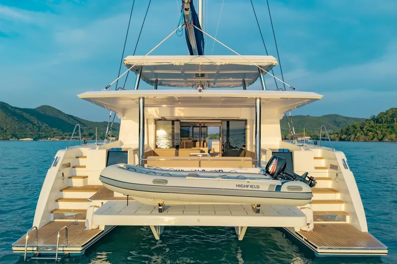 Slide: The Image of 2026 Island Spirit 525E yacht with tender, anchored in scenic waters. - 16