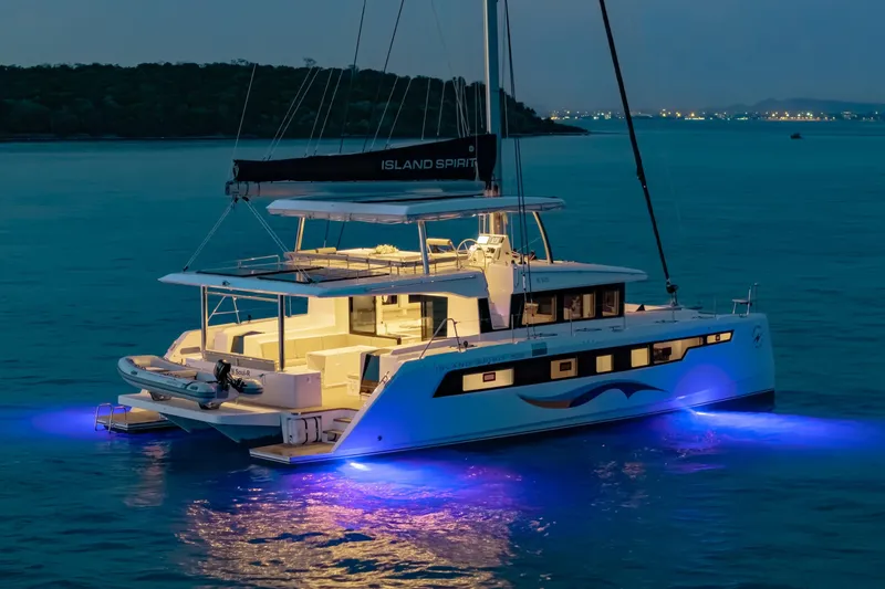 Slide: The Image of 2026 Island Spirit 525E catamaran illuminated at night on tranquil waters. - 17