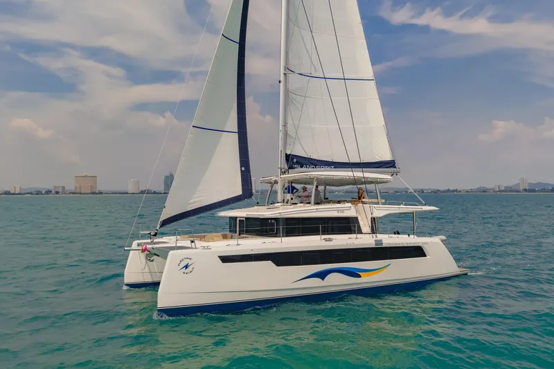 Slide: The Image of 2026 Island Spirit 525E catamaran sailing on blue ocean under clear sky. - 2