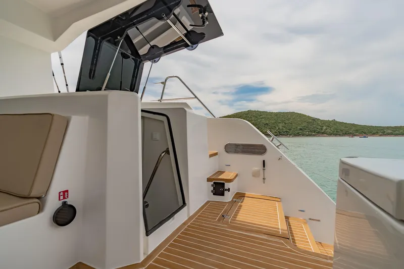 Slide: The Image of 2026 Island Spirit 525E yacht deck with seating, steps, and scenic ocean view. - 29