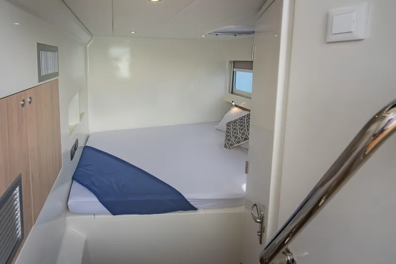 Slide: The Image of Cozy cabin interior of 2026 Island Spirit 525E yacht with bed and window. - 30
