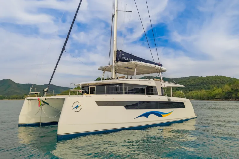 Slide: The Image of 2026 Island Spirit 525E catamaran sailing on calm waters with scenic backdrop. - 5