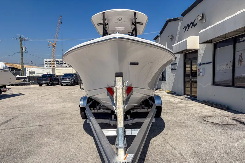 Slide: The Image of Sea Hunt Ultra 219 boat on trailer in front of building, 2026 model. - 3