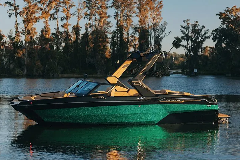 Slide: The Image of Manufacturer Provided Image: 2025 MasterCraft XStar 23 boat on a serene lake with trees in the background. - 16