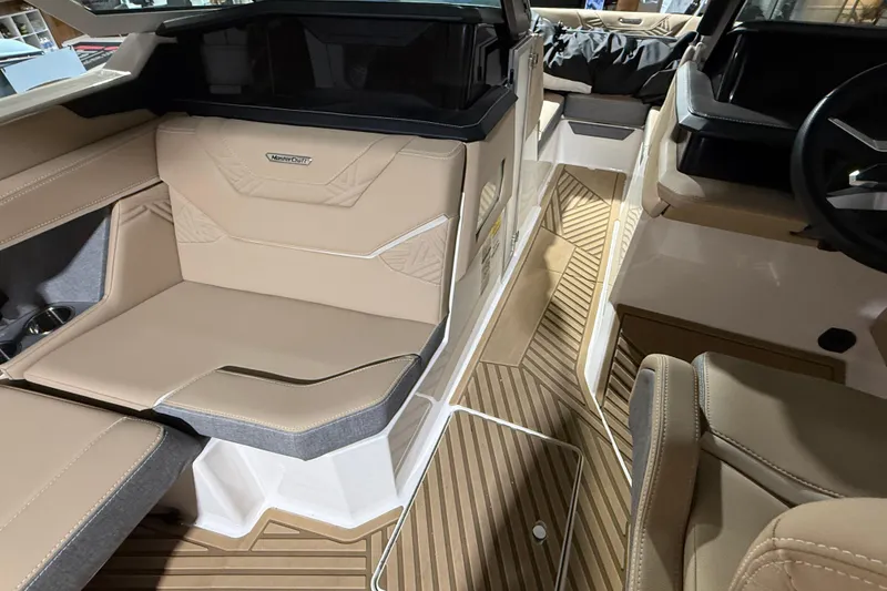 Slide: The Image of 2025 MasterCraft XStar 23 interior with beige seating and wood-patterned flooring. - 3