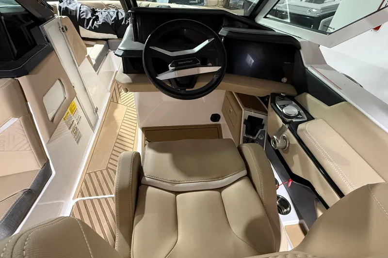Slide: The Image of 2025 MasterCraft XStar 23 boat interior with beige seating and modern steering console. - 7