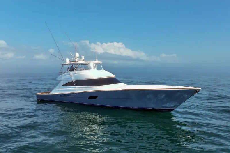 Slide: The Image of 2025 Viking 90 Convertible yacht cruising on open sea under clear blue sky. - 115