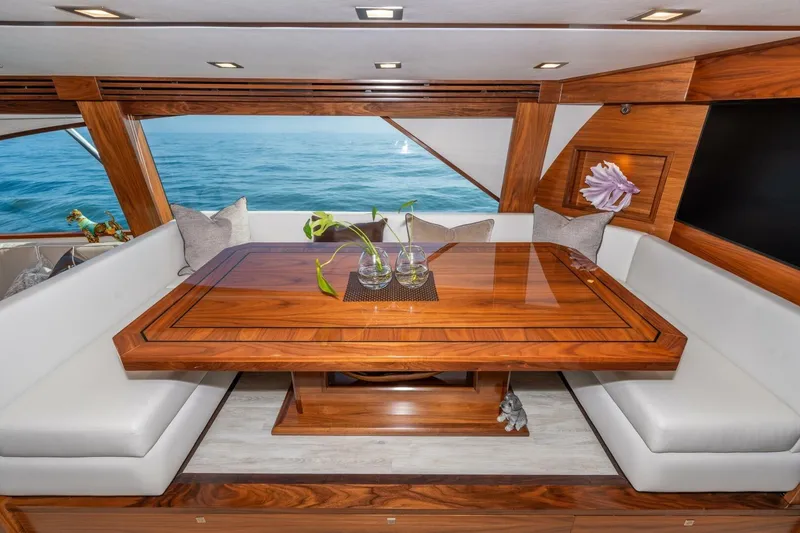 Slide: The Image of Luxurious interior of 2025 Viking 90 Convertible yacht with elegant wood table and ocean view. - 23