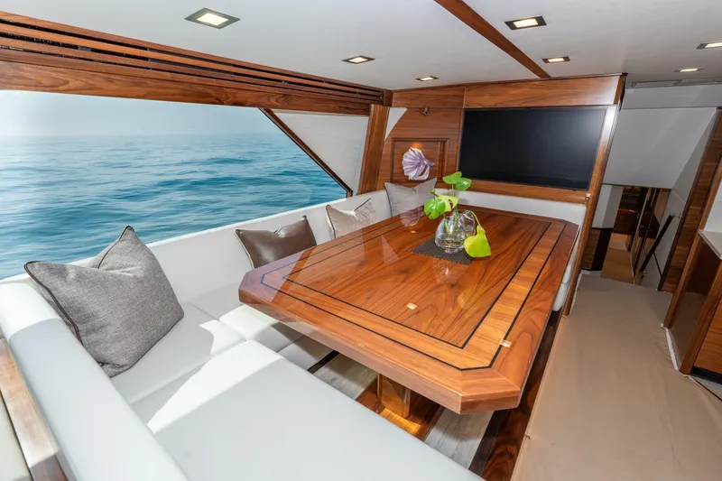 Slide: The Image of Luxurious interior of 2025 Viking 90 Convertible yacht with elegant wood dining table and ocean view. - 26