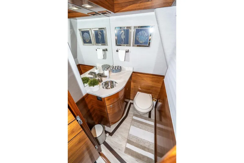 Slide: The Image of Luxurious bathroom in 2025 Viking 90 Convertible yacht with wood accents and nautical decor. - 32