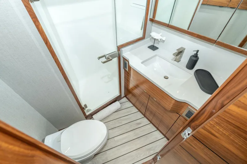 Slide: The Image of Luxurious bathroom in 2025 Viking 90 Convertible yacht with modern fixtures and wooden accents. - 48