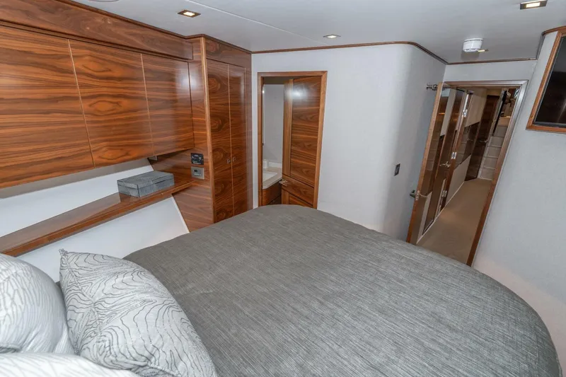 Slide: The Image of Luxurious bedroom interior of 2025 Viking 90 Convertible yacht with wood paneling and modern design. - 53