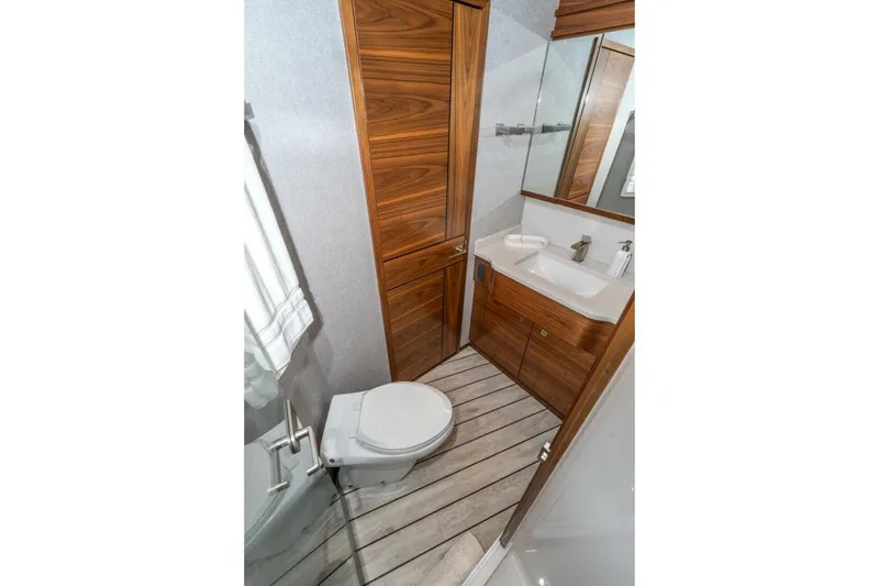 Slide: The Image of Luxurious bathroom in 2025 Viking 90 Convertible yacht with wood accents and modern fixtures. - 54