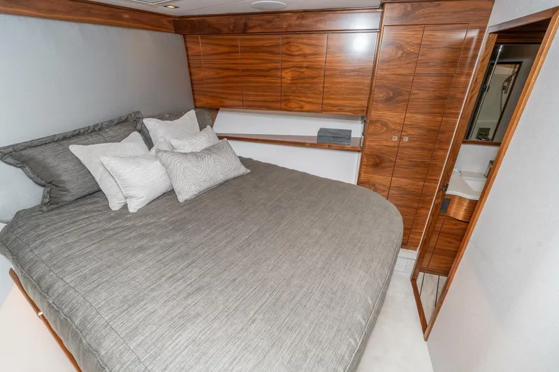 Slide: The Image of Luxurious bedroom interior of 2025 Viking 90 Convertible yacht with elegant wood finishes. - 55