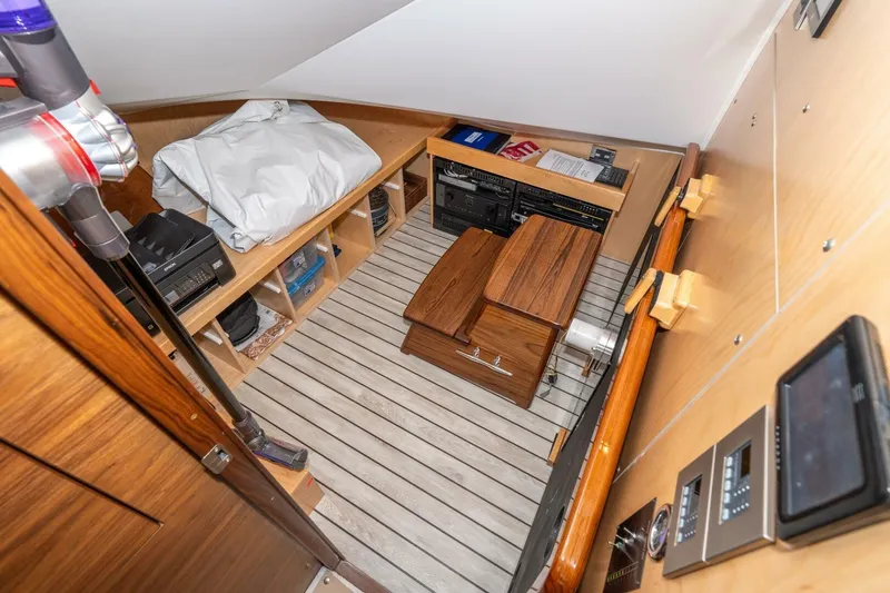 Slide: The Image of Interior of 2025 Viking 90 Convertible yacht with wooden flooring and storage compartments. - 61