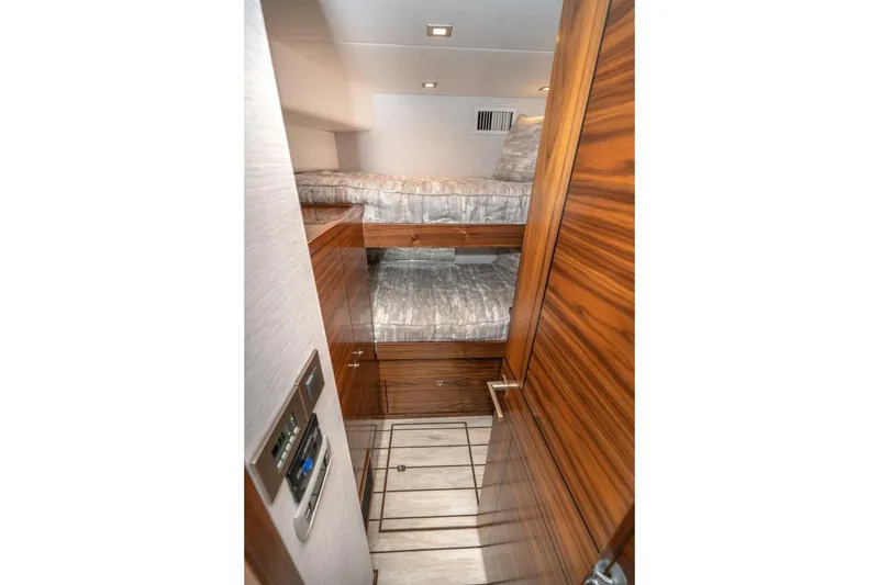 Slide: The Image of 2025 Viking 90 Convertible yacht interior with wooden bunk beds and modern design. - 66