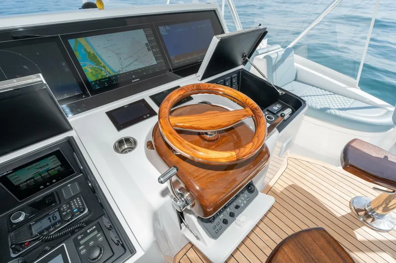 Slide: The Image of 2025 Viking 90 Convertible yacht helm with advanced navigation systems and wooden steering wheel. - 7