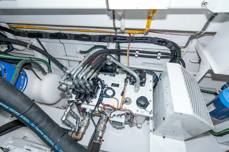Slide: The Image of Engine room of 2025 Viking 90 Convertible yacht, showcasing complex machinery and wiring. - 73