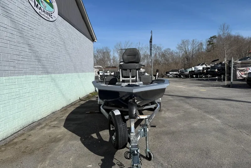 Slide: The Image of 2026 Xpress H20B Bay boat on trailer outside marine dealership. - 2