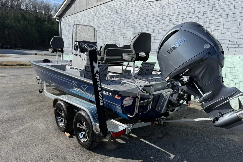 Slide: The Image of 2026 Xpress H20B Bay boat with Yamaha engine on trailer, parked outdoors. - 3