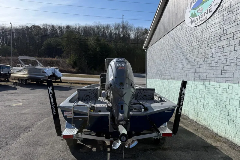 Slide: The Image of 2026 Xpress H20B Bay boat with outboard motor at a marine dealership. - 4
