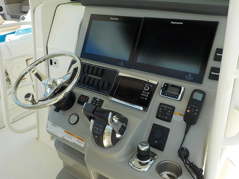 Slide: The Image of Control panel of a 2016 Boston Whaler 370 Outrage with dual screens and steering wheel. - 12