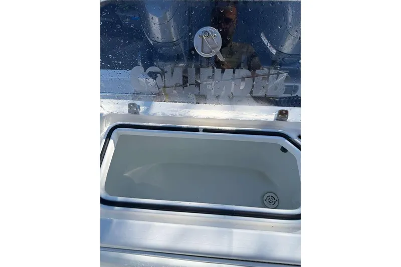 Slide: The Image of Open storage compartment on a 2022 Contender 35 ST boat, with water droplets on the lid. - 30