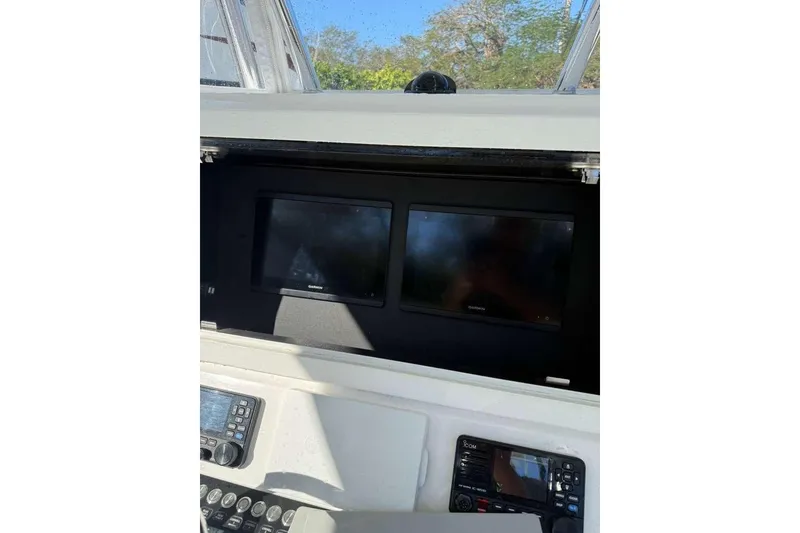 Slide: The Image of 2022 Contender 35 ST boat dashboard with dual Garmin displays and control panel. - 35