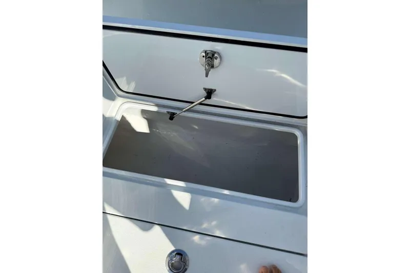 Slide: The Image of Open storage compartment on 2022 Contender 35 ST boat, featuring secure latch mechanism. - 42