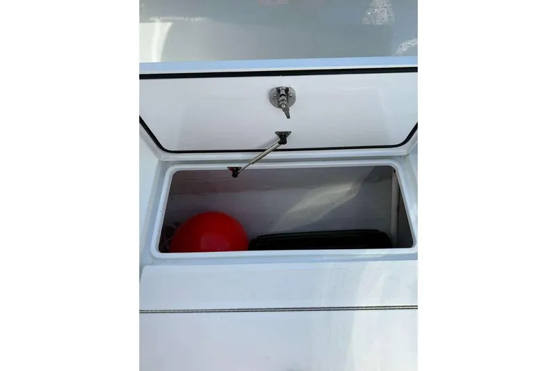 Slide: The Image of Open storage compartment in 2022 Contender 35 ST boat with red buoy inside. - 45