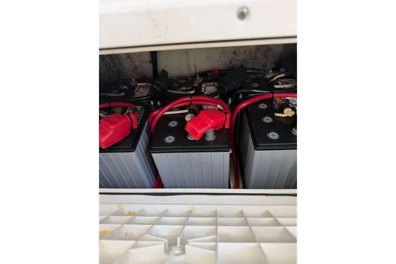 Slide: The Image of Batteries in a 2022 Contender 35 ST boat, connected with red cables. - 49