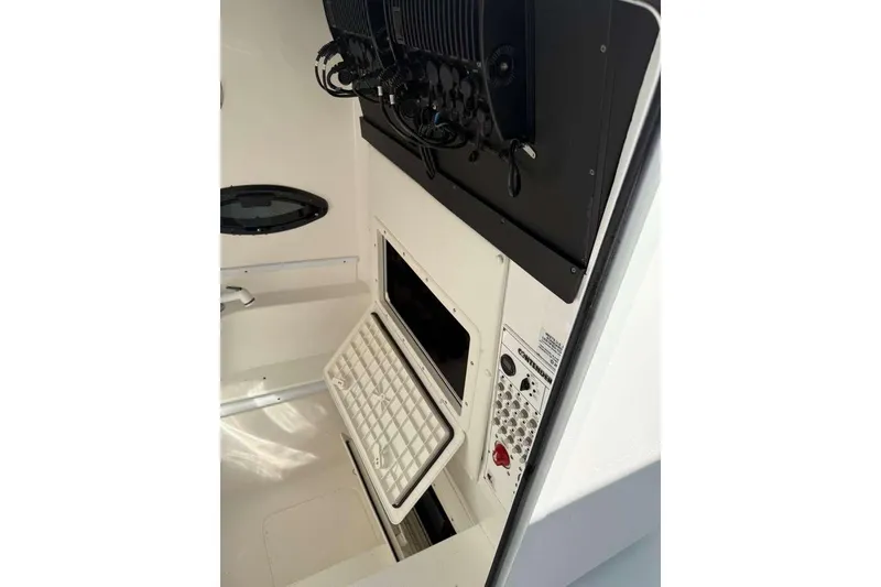 Slide: The Image of 2022 Contender 35 ST boat interior with open storage compartment and control panel. - 52