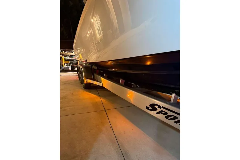 Slide: The Image of 2022 Contender 35 ST boat on trailer, illuminated in a garage setting. - 65