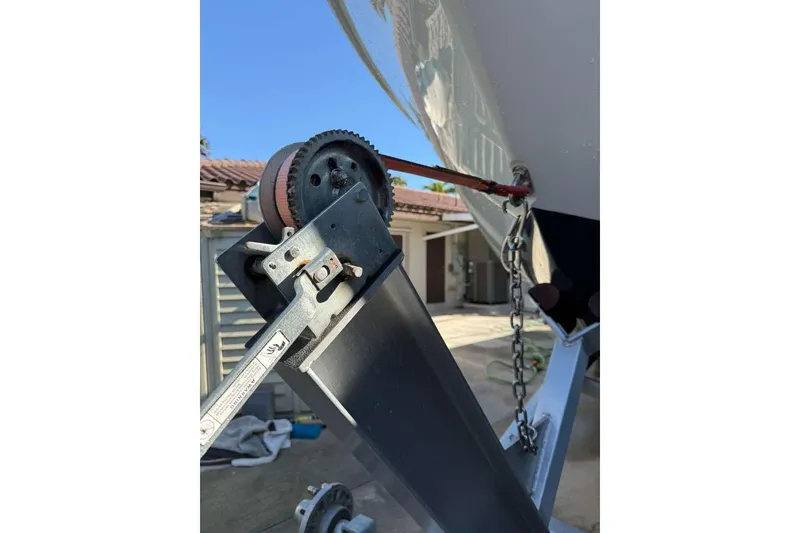 Slide: The Image of 2022 Contender 35 ST boat trailer winch and chain mechanism in a driveway setting. - 9