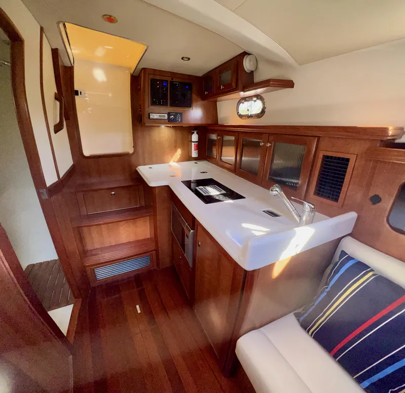 Slide: The Image of Interior of 2016 Marlow Pilot 31, featuring a compact kitchen and seating area. - 26